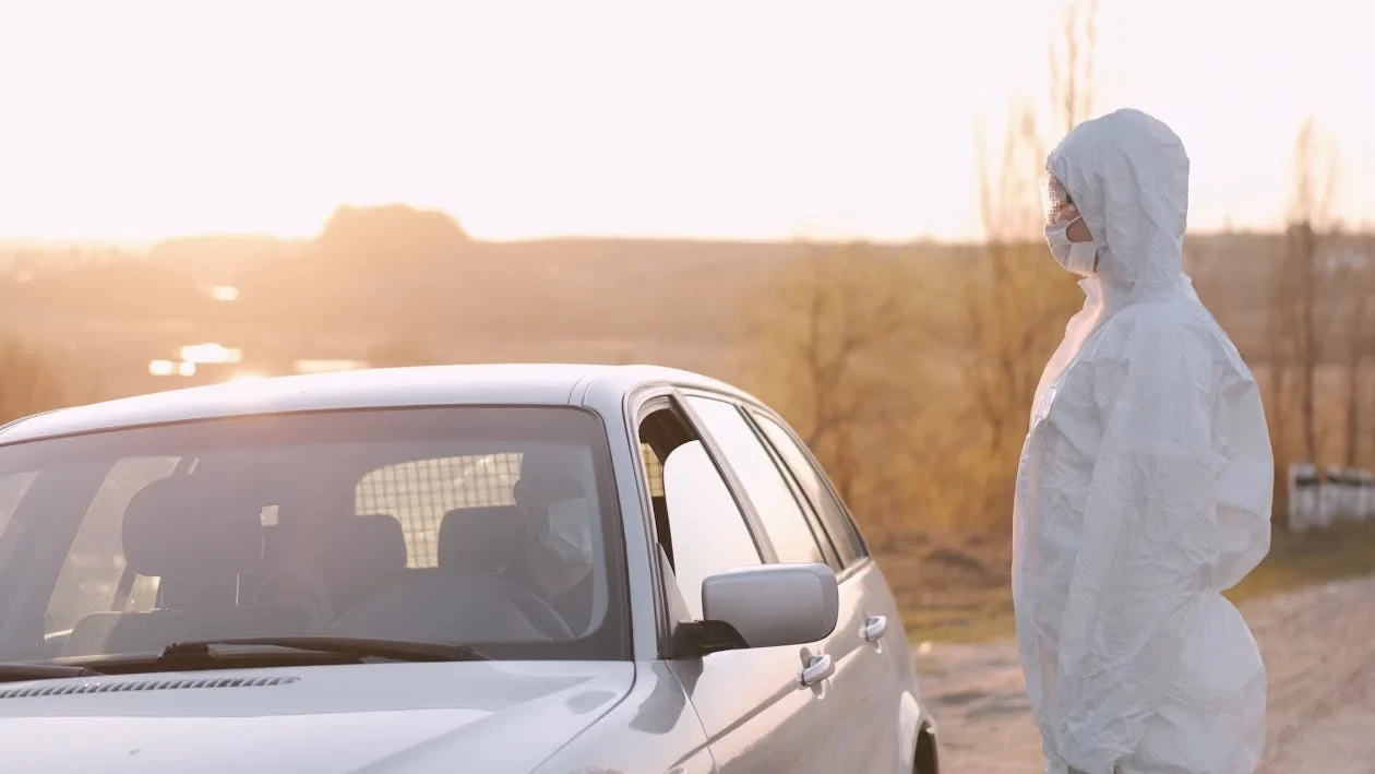 Person In a Hazmat Suit Checking a Driver's Temperature